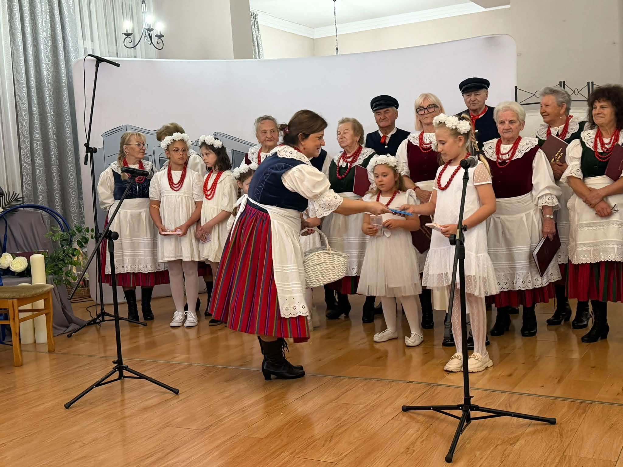 Uczennica otrzymuje upominek podczas jubileuszowej uroczystości.