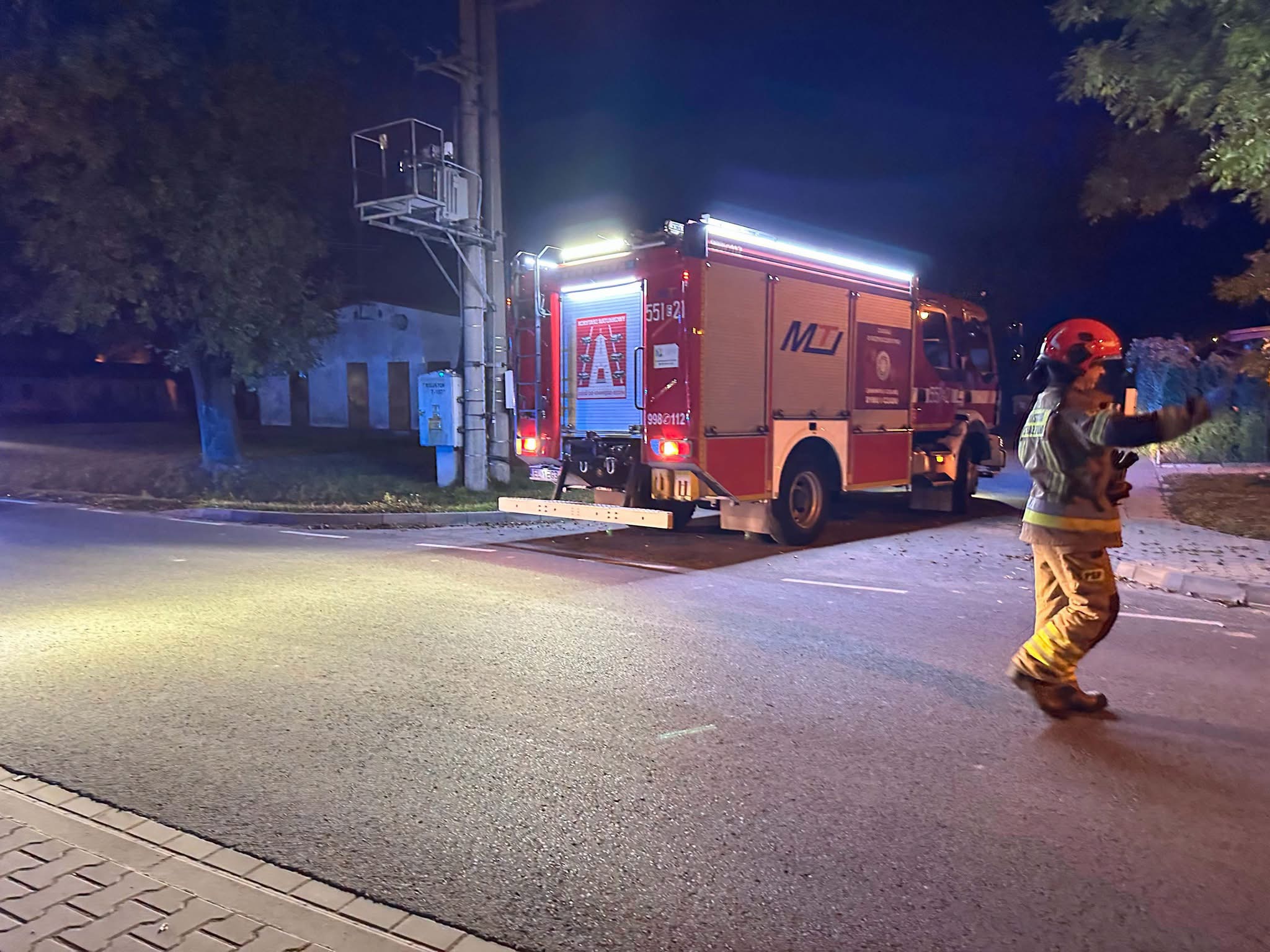 Samochód straży pożarnej i strażak kierujący ruchem przy ulicy. Fot. M.M.
