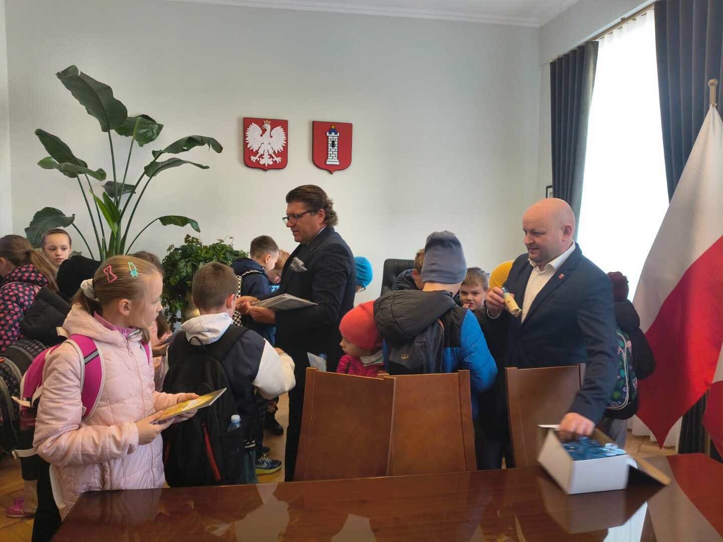 Uczniowie rozmawiają z przedstawicielami samorządu w ratuszu.