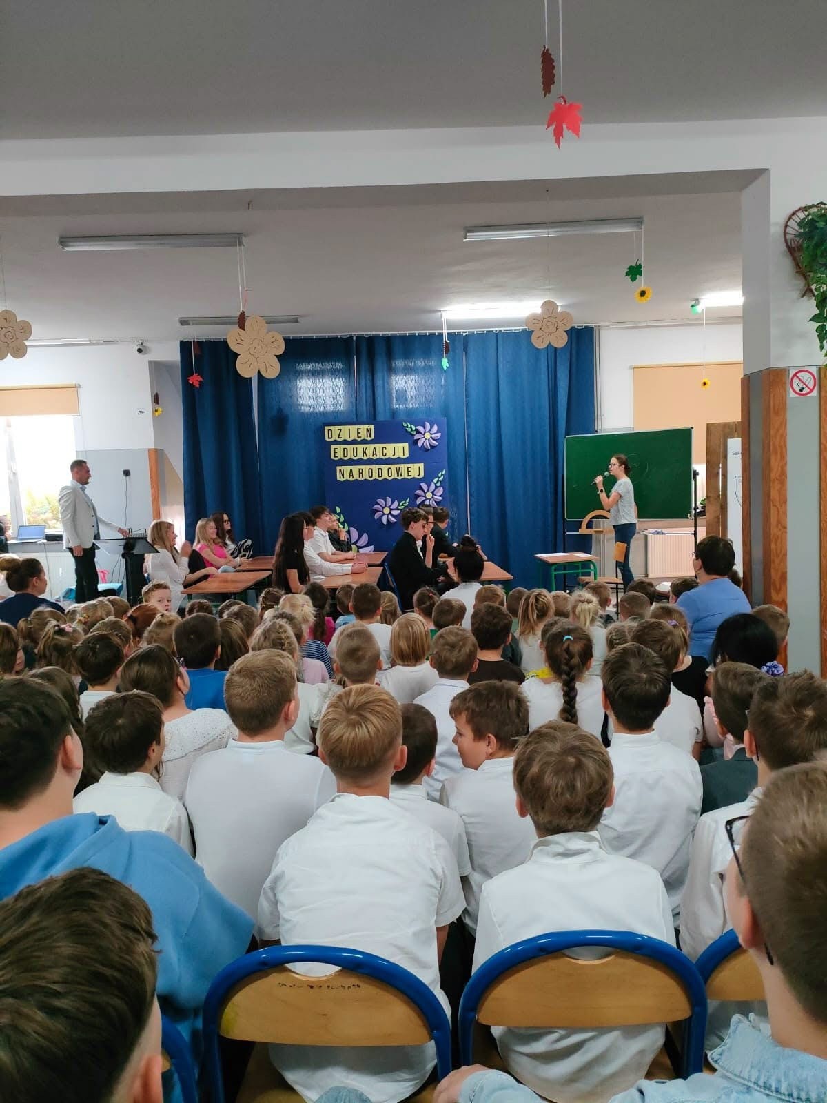 Uczniowie prezentują scenkę przy tablicy przed publicznością. Fot. Szkoła Podstawowa im. Henryka Sienkiewicza w Wierzchlesie.