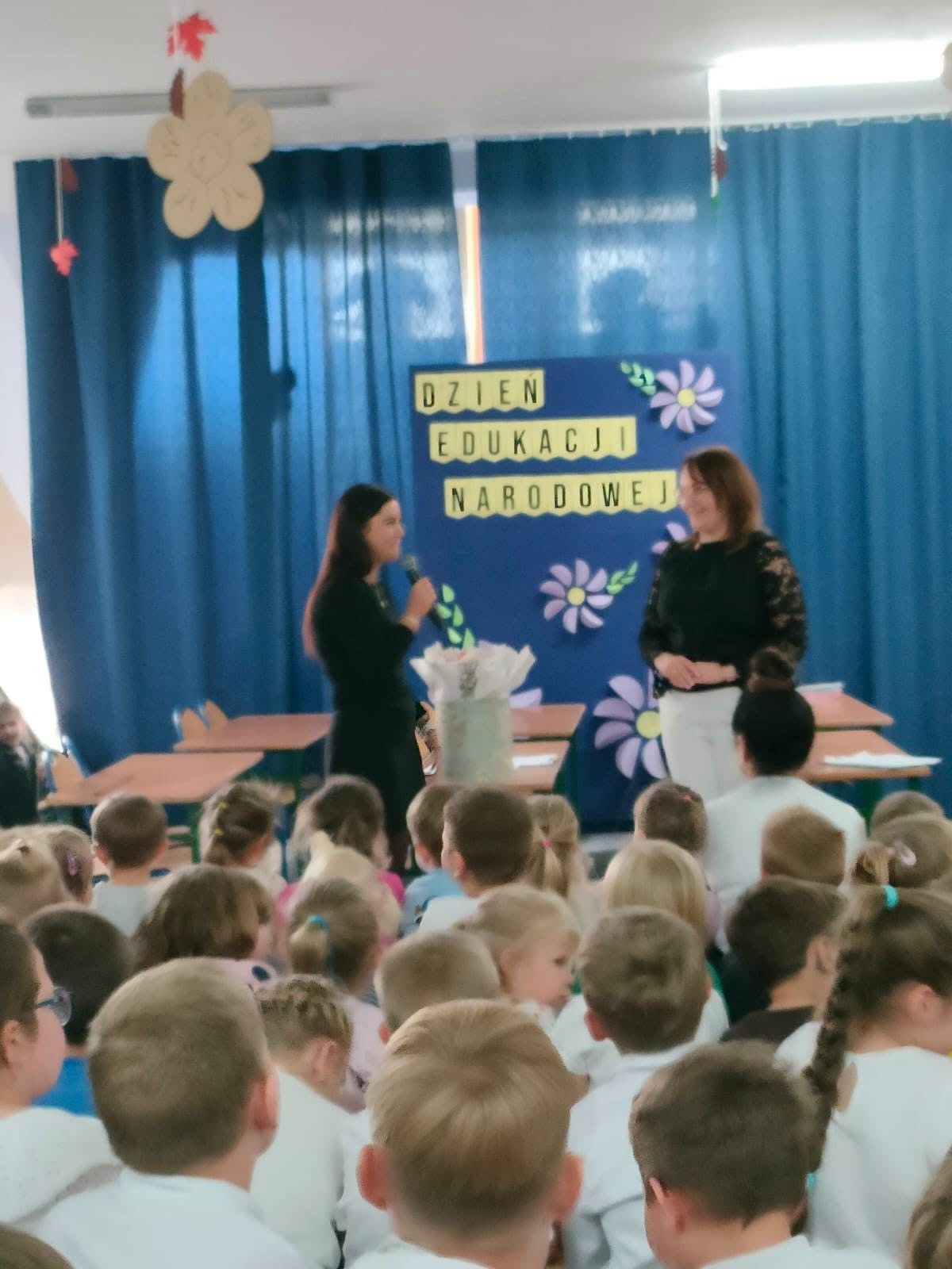 Uczennica występuje z mikrofonem w trakcie szkolnego przedstawienia. Fot. Szkoła Podstawowa im. Henryka Sienkiewicza w Wierzchlesie.